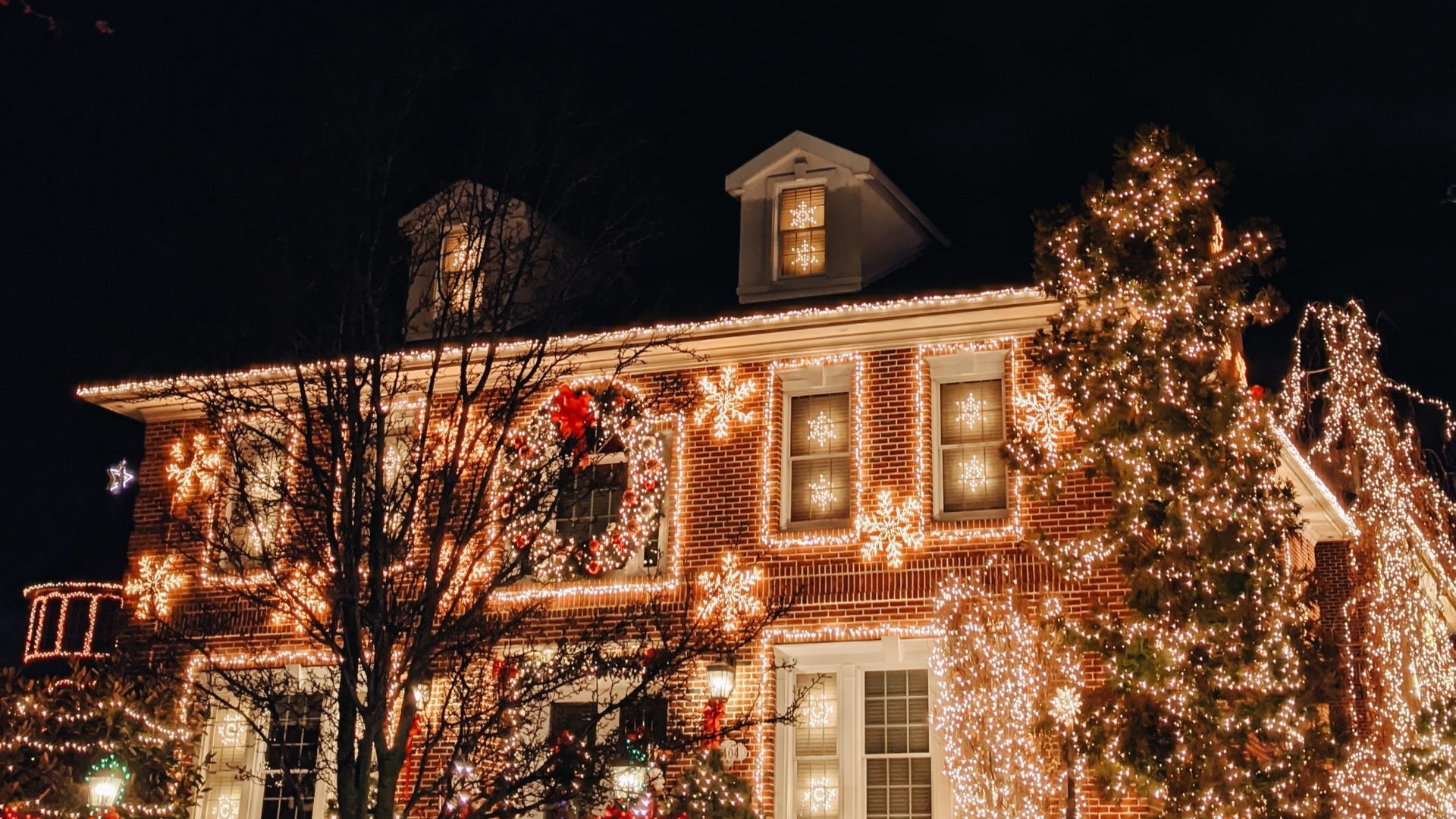 House covered in many Christmas lights including on the roof.